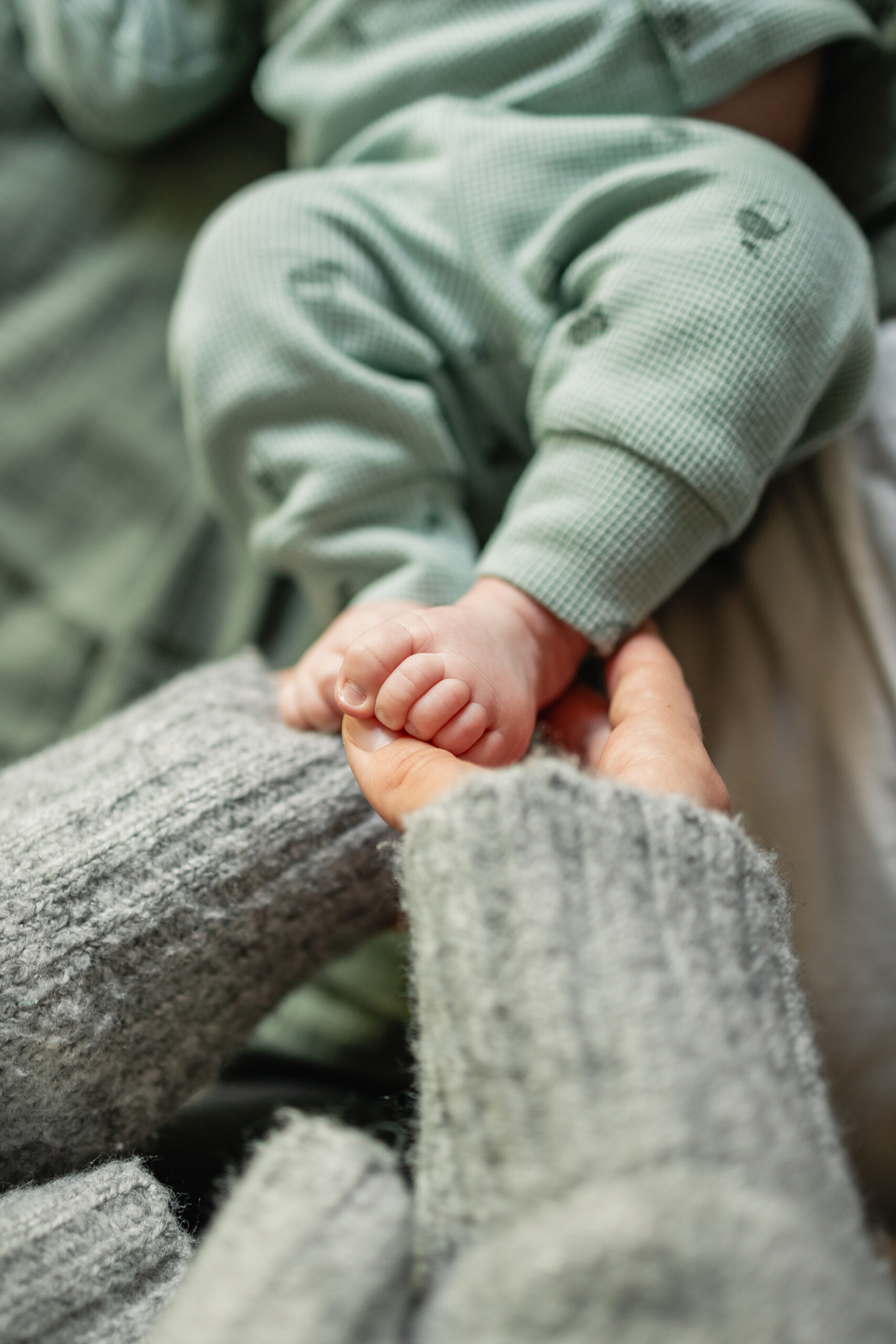 leep support for newborn with caregiver holding baby hands in calm setting
